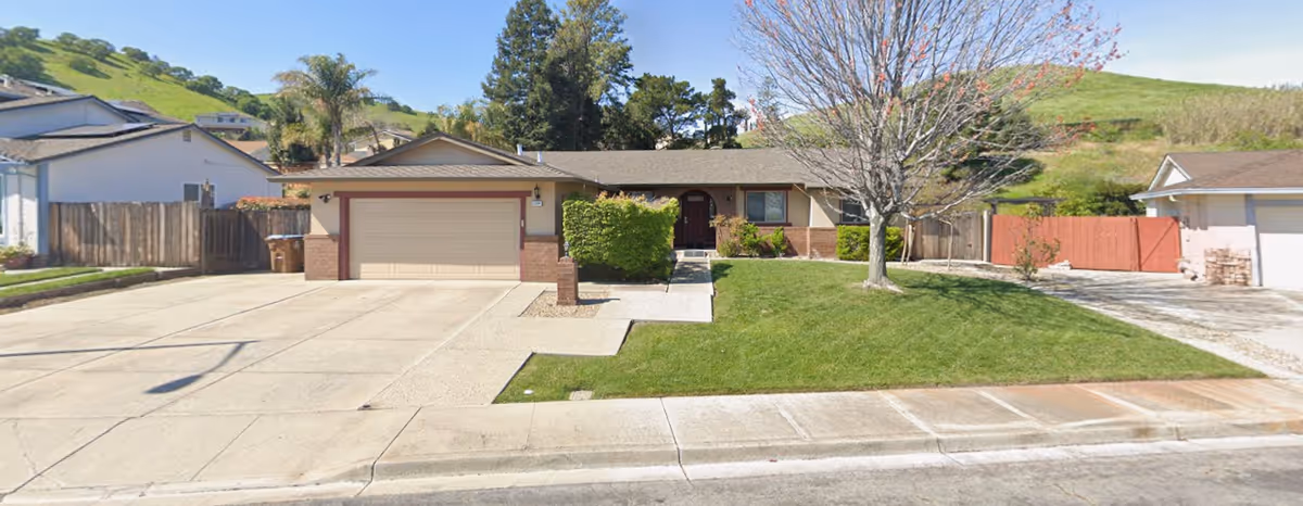 Front view of Oasis Bay Care facility with driveway and well kept lawn