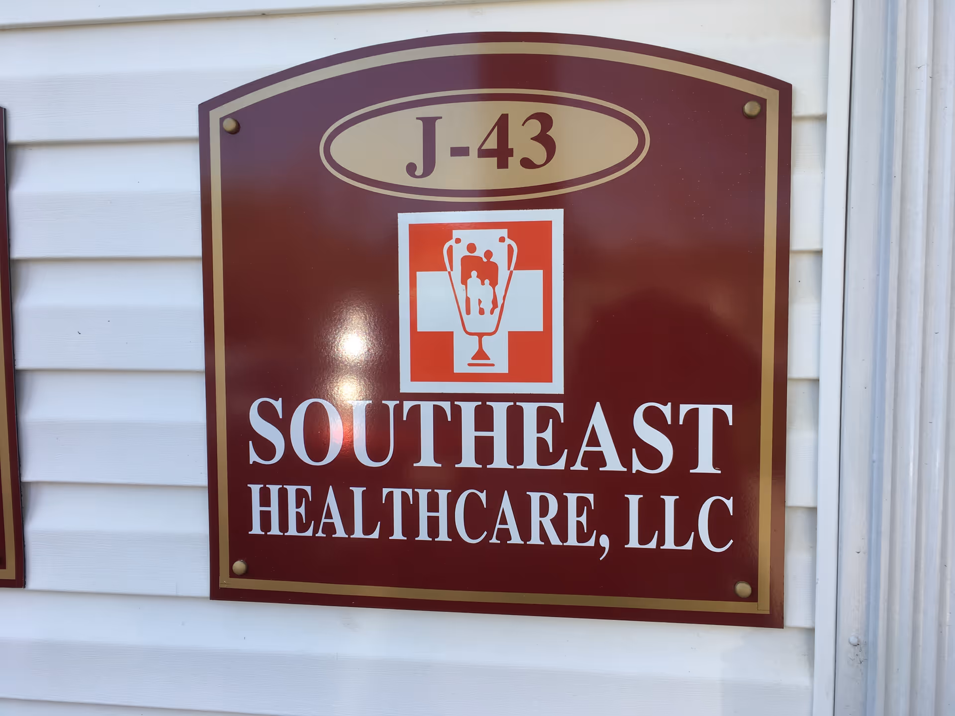 Maroon Southeast Healthcare, LLC sign with emblem mounted on white exterior siding.