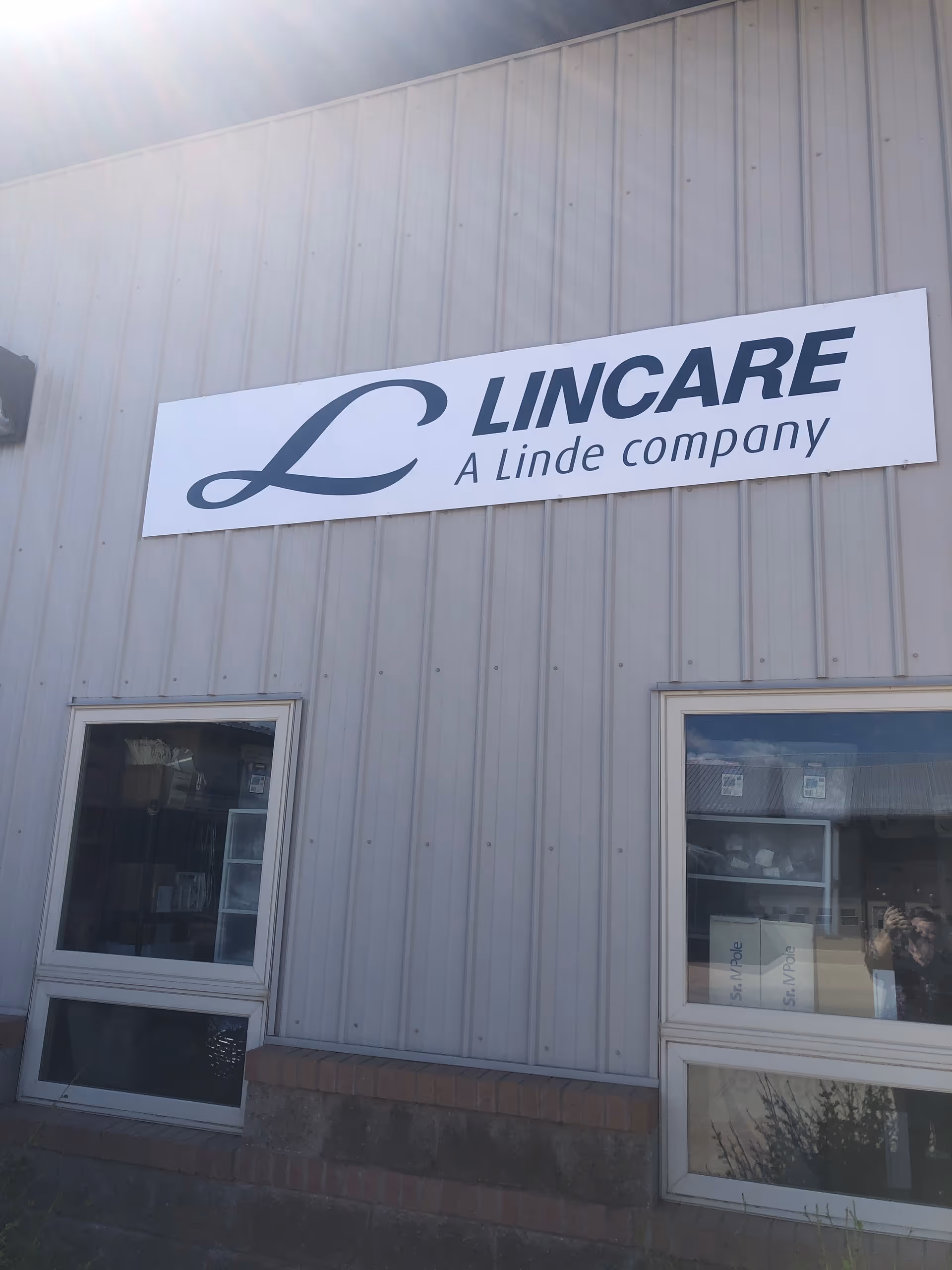 Exterior of a metal building with a LINCARE sign and two front windows.