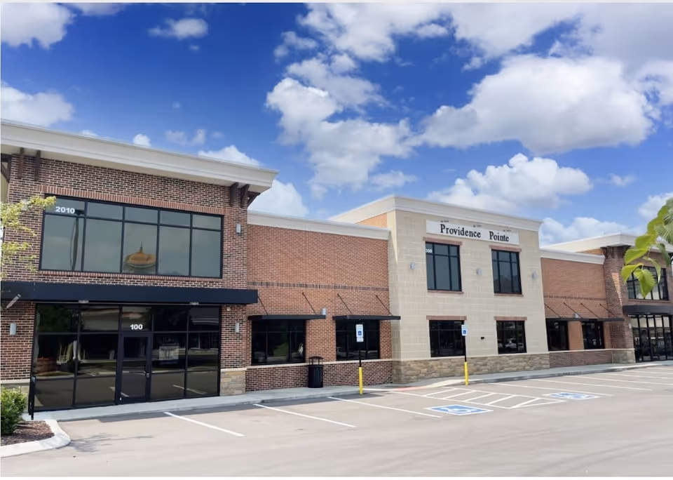 Exterior view of Providence Pointe facility with brick facade and parking lot.