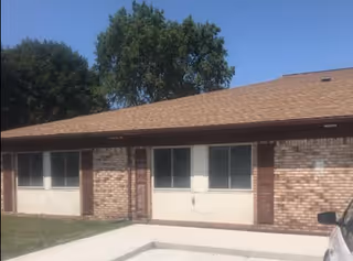 Single-story brick facility exterior with windows and a concrete walkway.