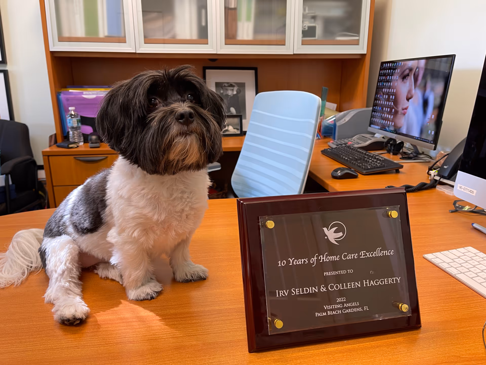 Office desk at Visiting Angels Palm Beach Gardens with a dog and plaque