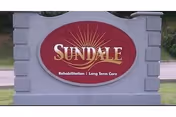 Sundale sign on a gray stone pedestal outdoors.
