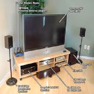 TV on a wooden stand with speakers and devices in a living room.