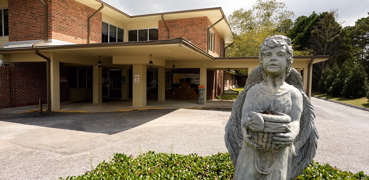 Brick Highland House entrance with a large angel statue in the foreground.