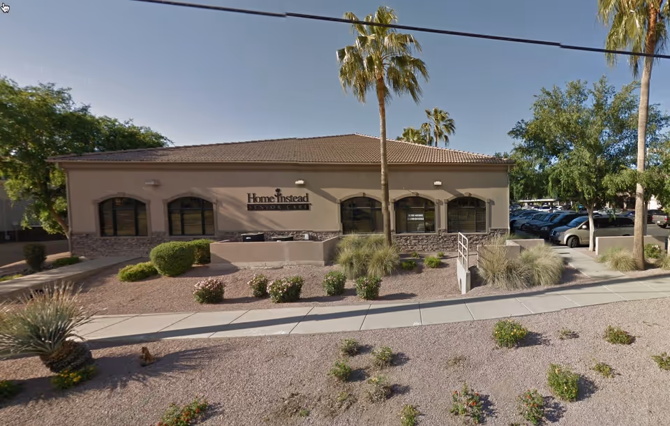 Front view of a single-story Home Instead Senior Care building with desert landscaping.