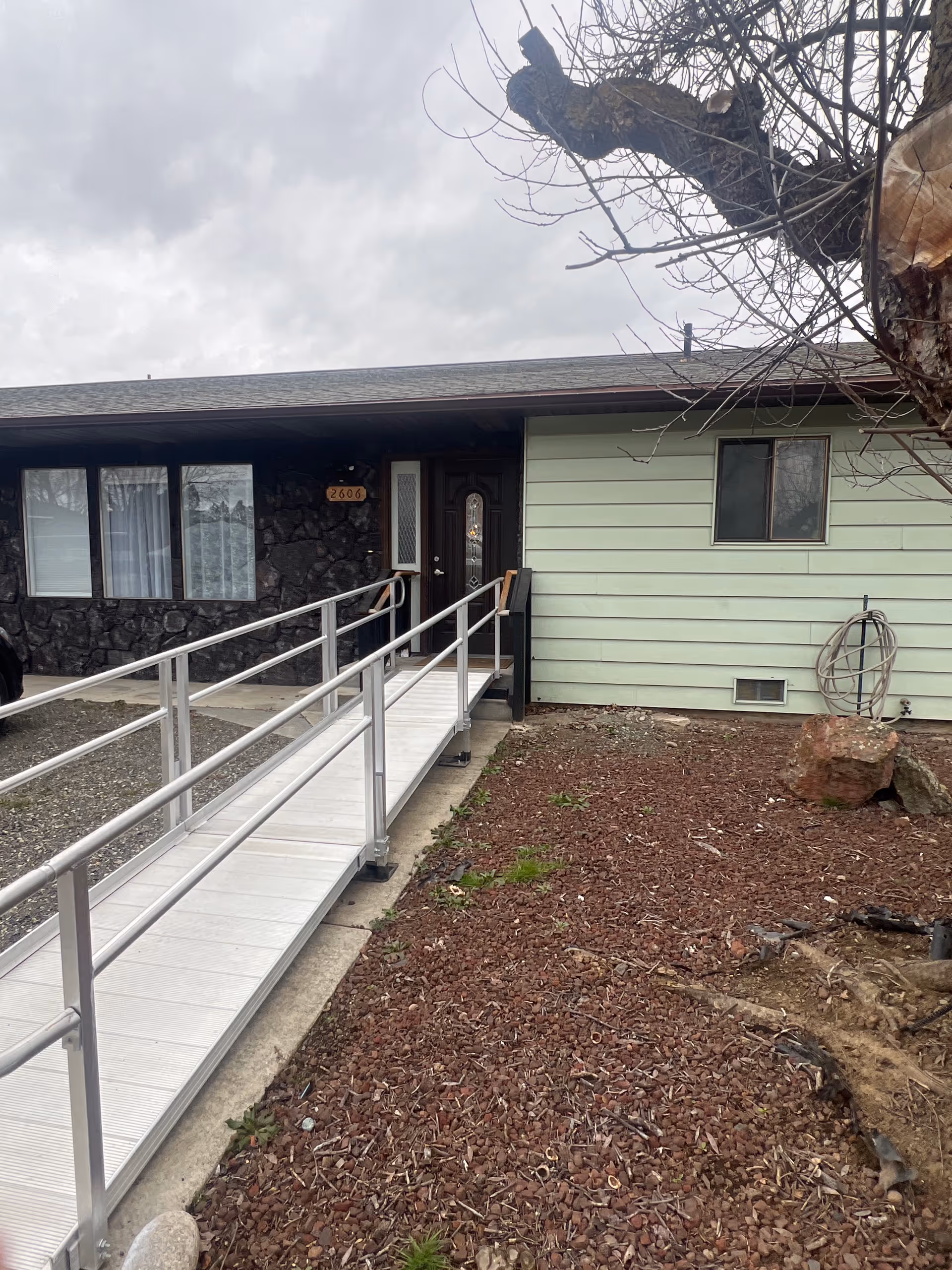 Exterior view of Clarkston care home entrance with a ramp and mulch yard.