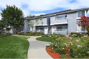 Exterior view of Nantucket Creek Senior Living with a curved walkway and manicured landscaping.