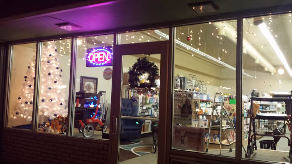 Storefront of Rocky Mountain Home Health Supplies with open sign, a festive tree, and shelves.