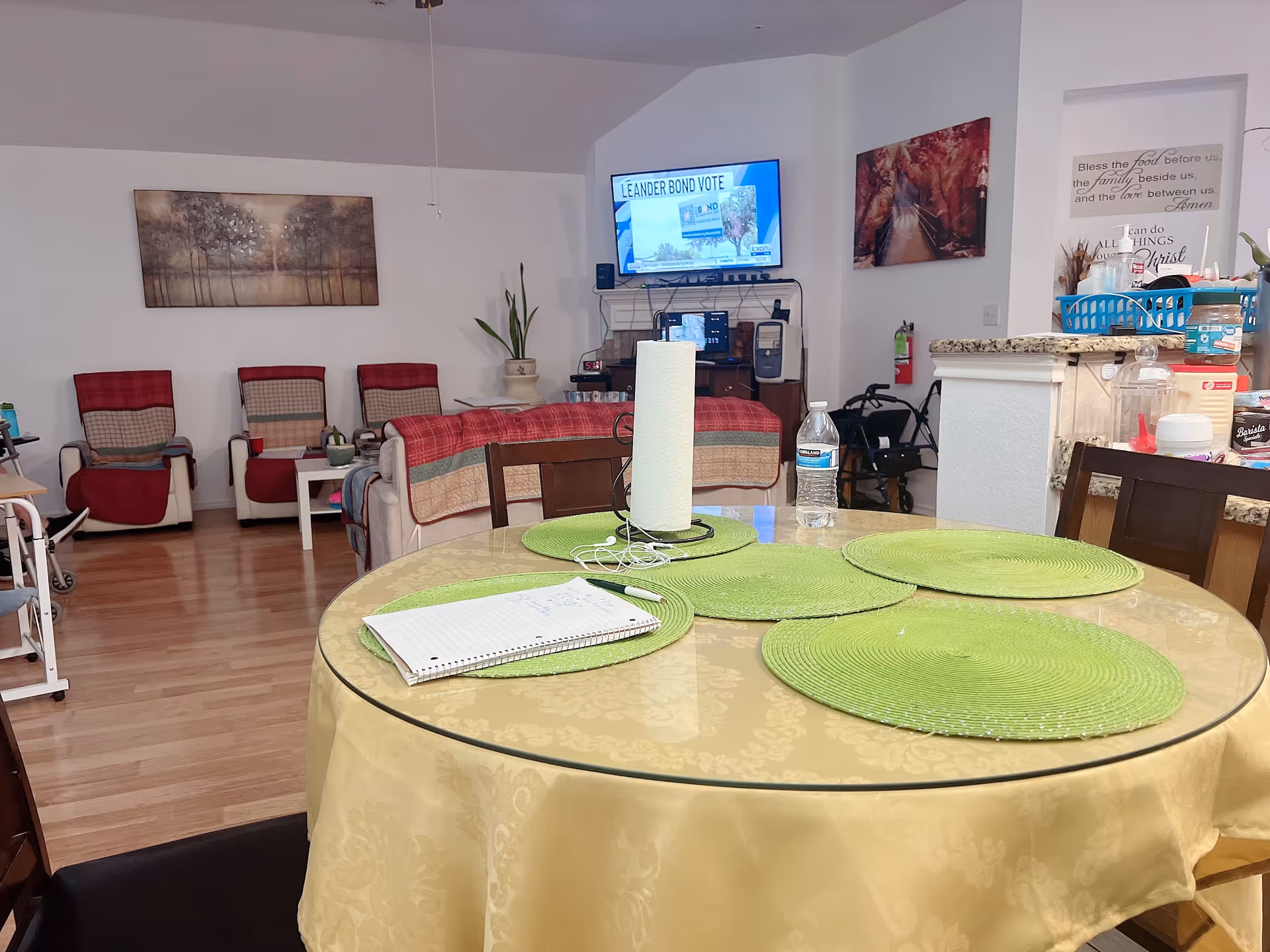 Round dining table with green placemats in a furnished senior living lounge area
