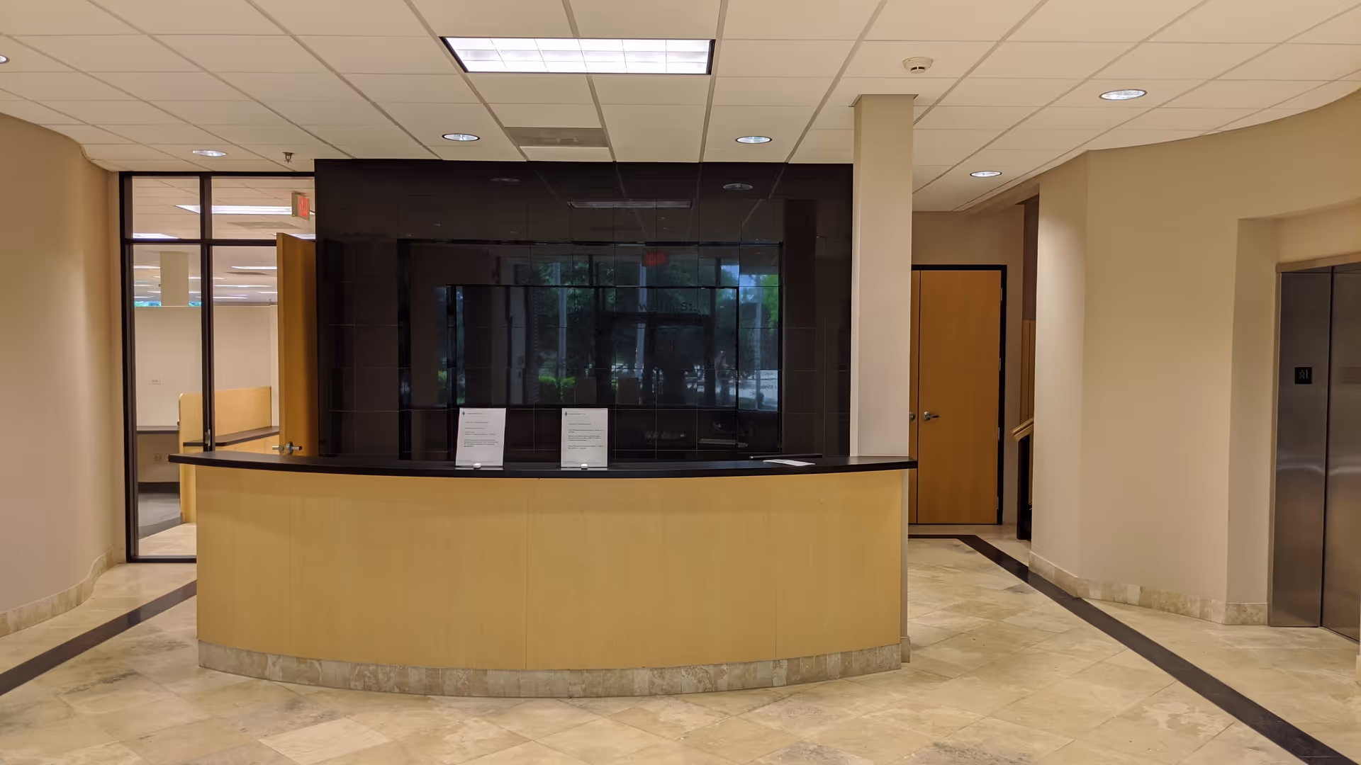 Reception desk in a modern senior care facility lobby with tile floor.