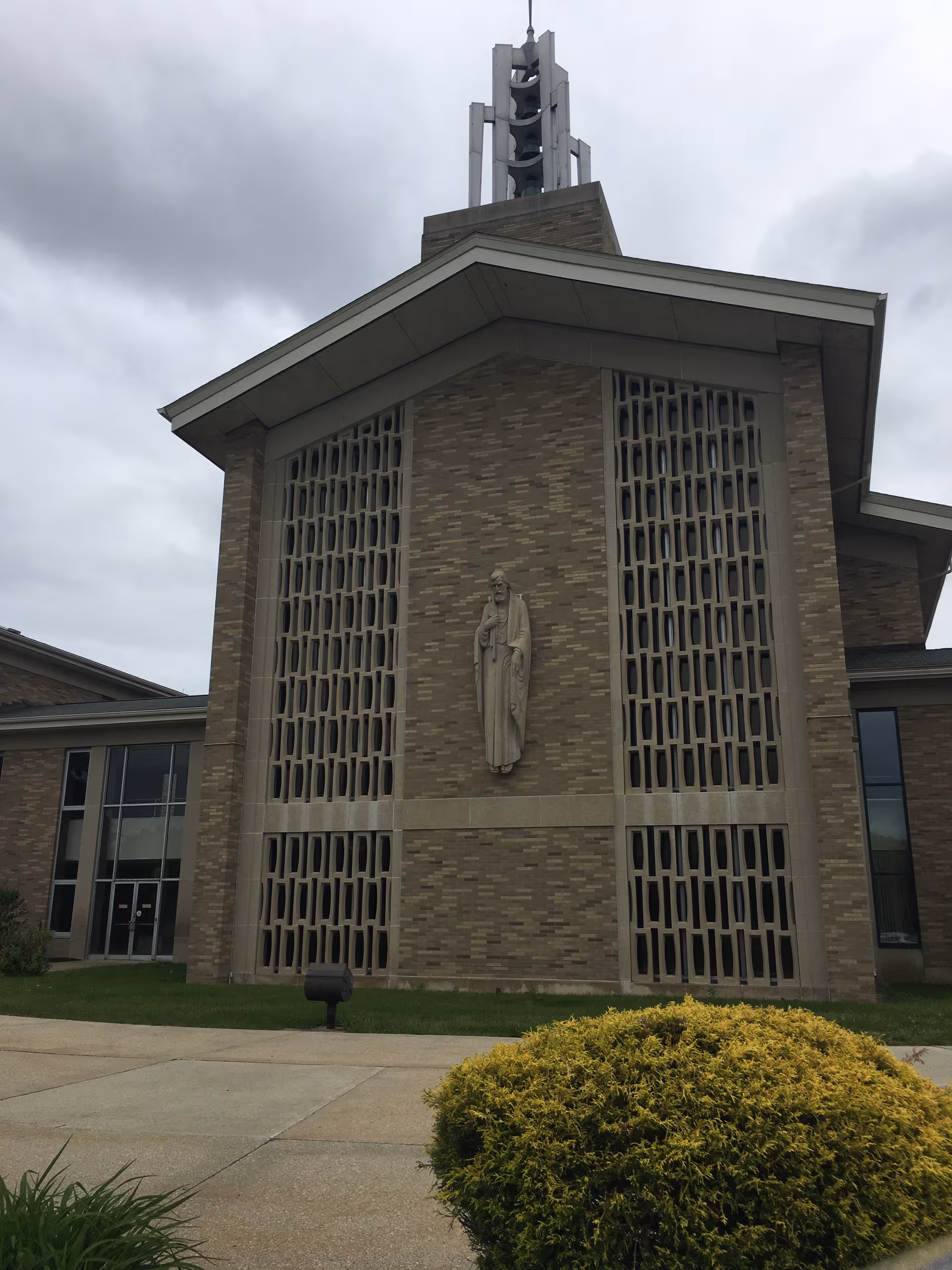 Front exterior of a brick Mont Marie facility with tall decorative windows and a central statue.