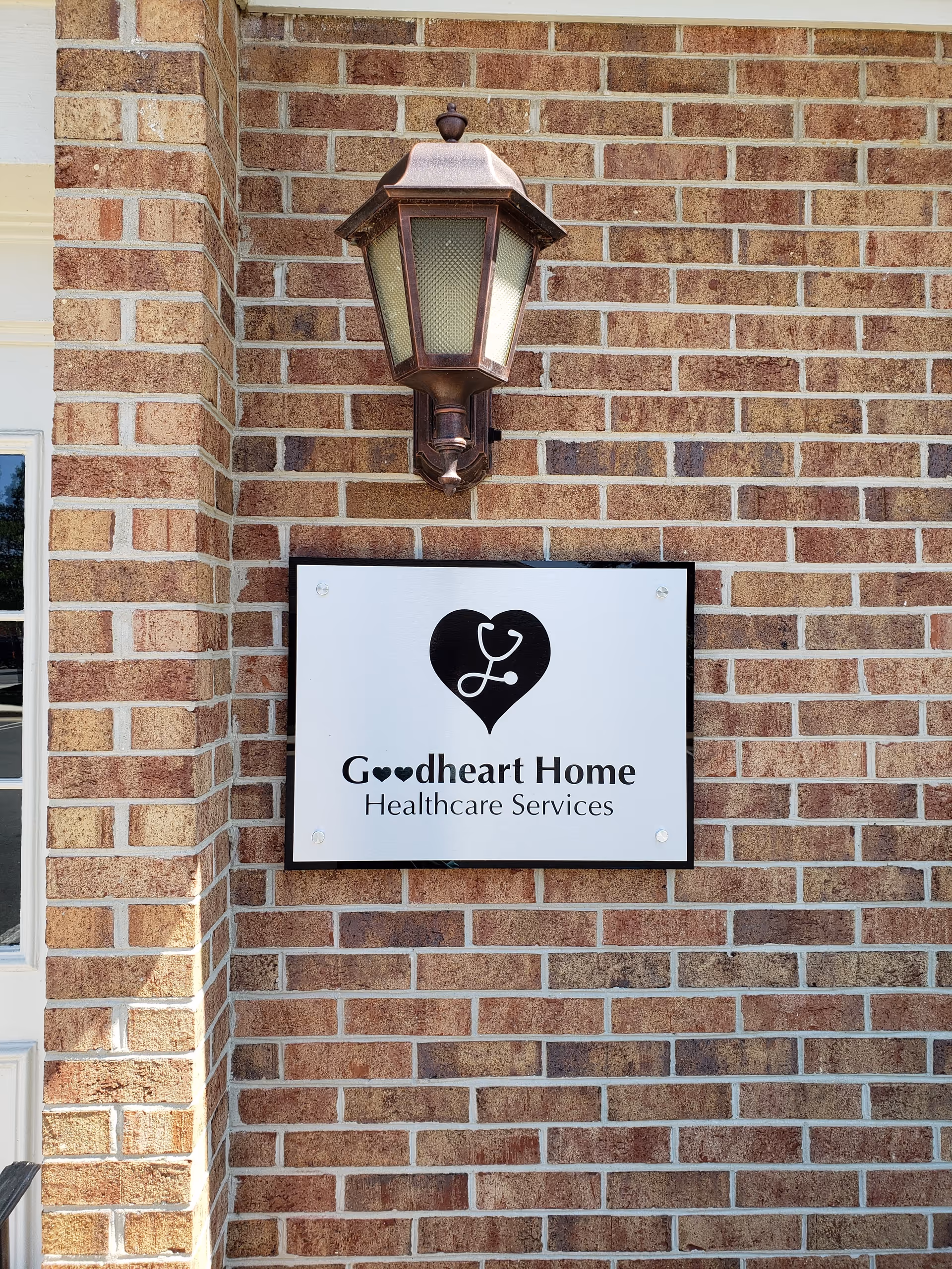 Brick exterior with a hanging lantern and a sign reading Goodheart Home Healthcare Services.