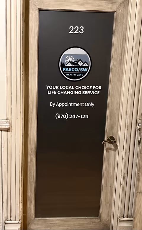 A dark door marked 223 with PASCO/SW Health Care logo, appointment-only notice, and phone number.