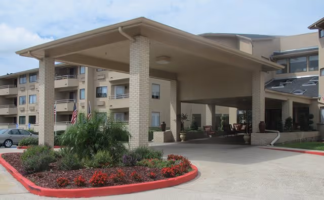 Exterior view of Silver Ridge Care entrance with a covered driveway and landscaped beds.