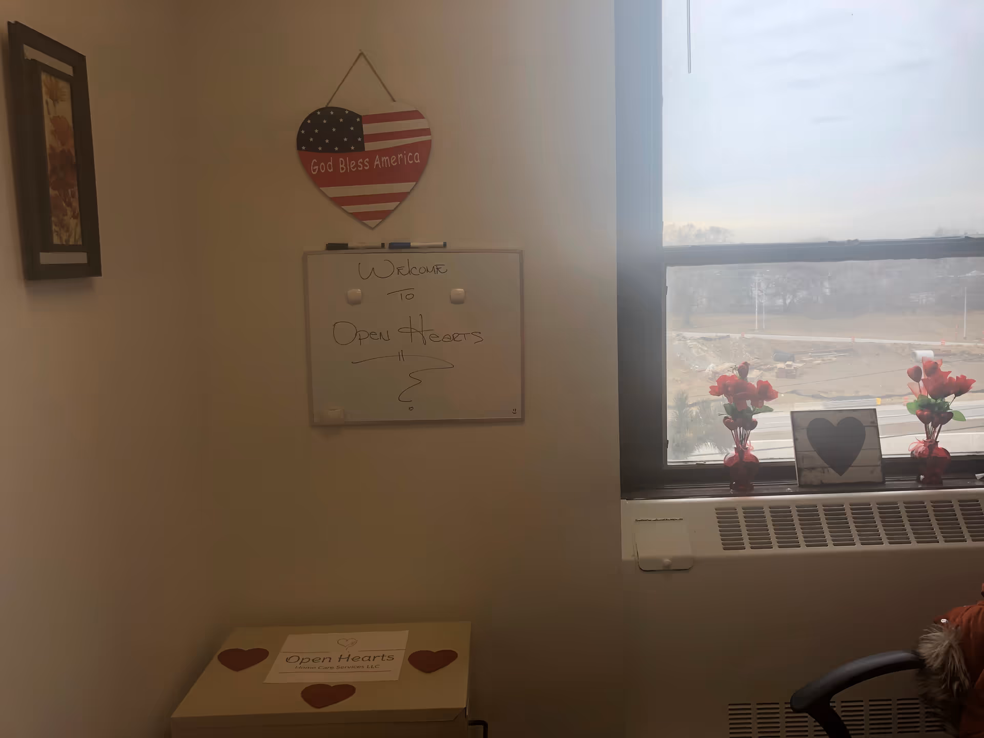 Interior room with a whiteboard, patriotic heart decor, and a windowsill display.