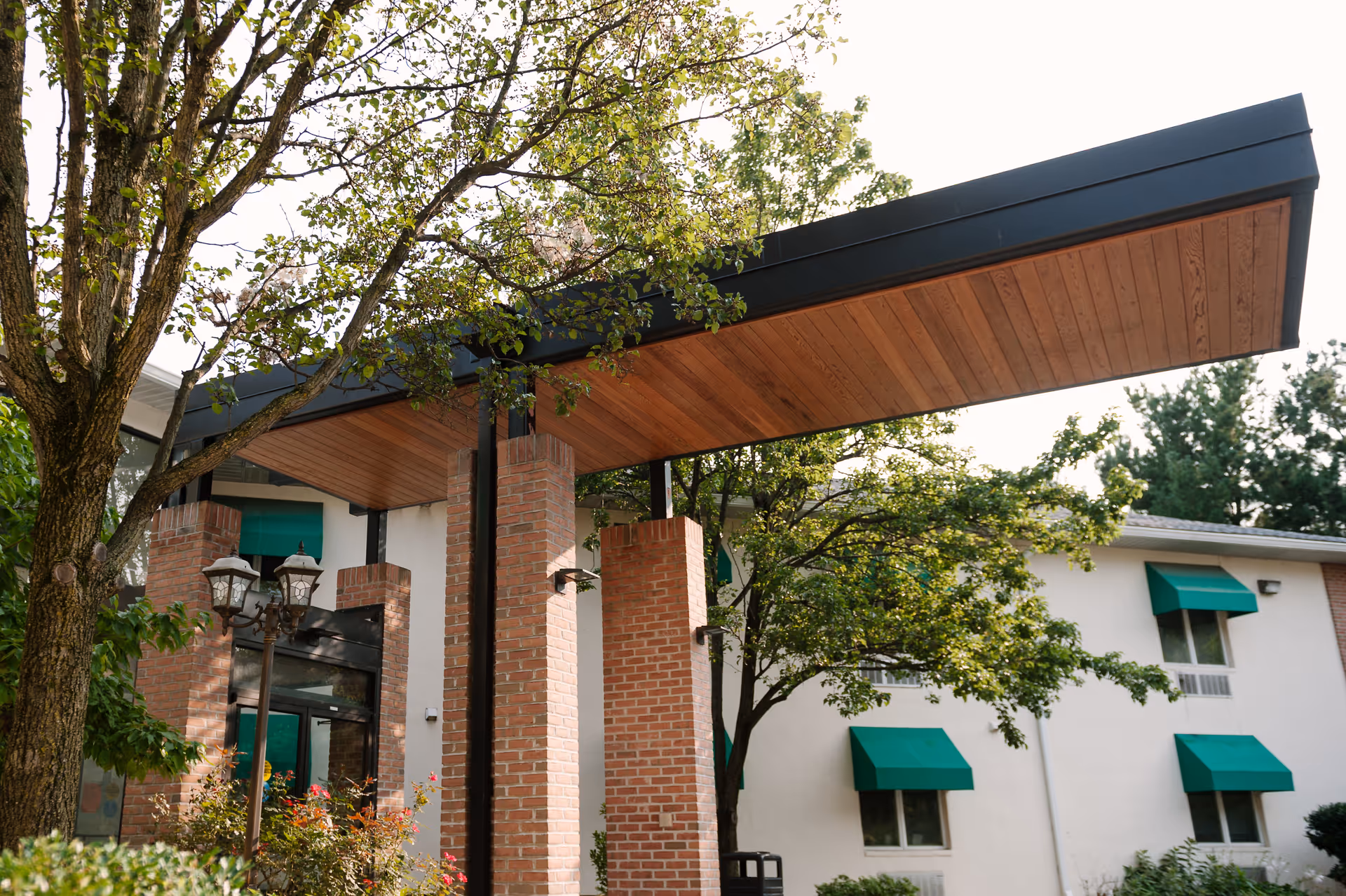 Exterior view of Autumn Lake Healthcare at Alice Manor with brick columns and green awnings.
