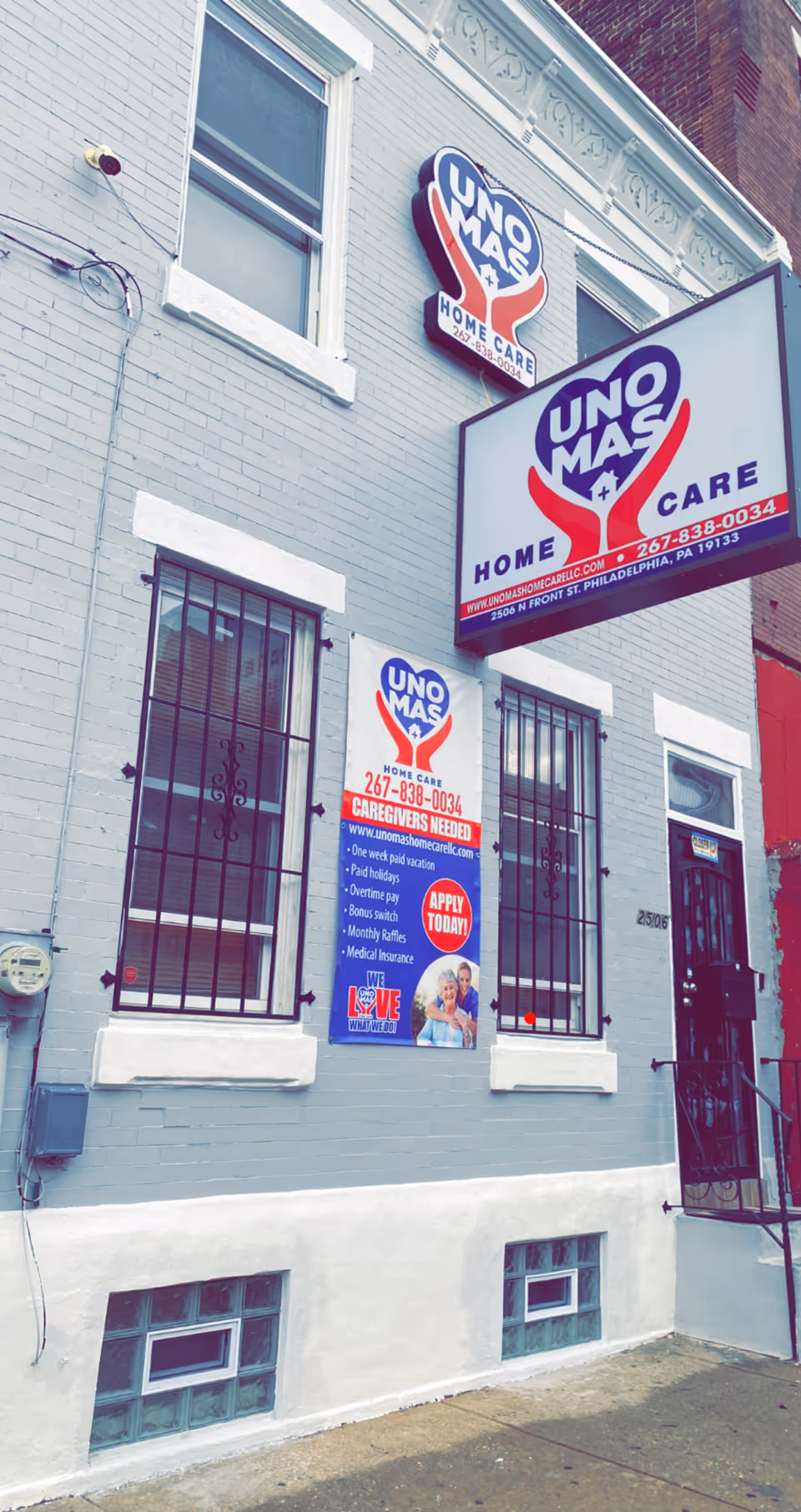 Exterior view of a brick building storefront with Uno Mas Home Care signs.