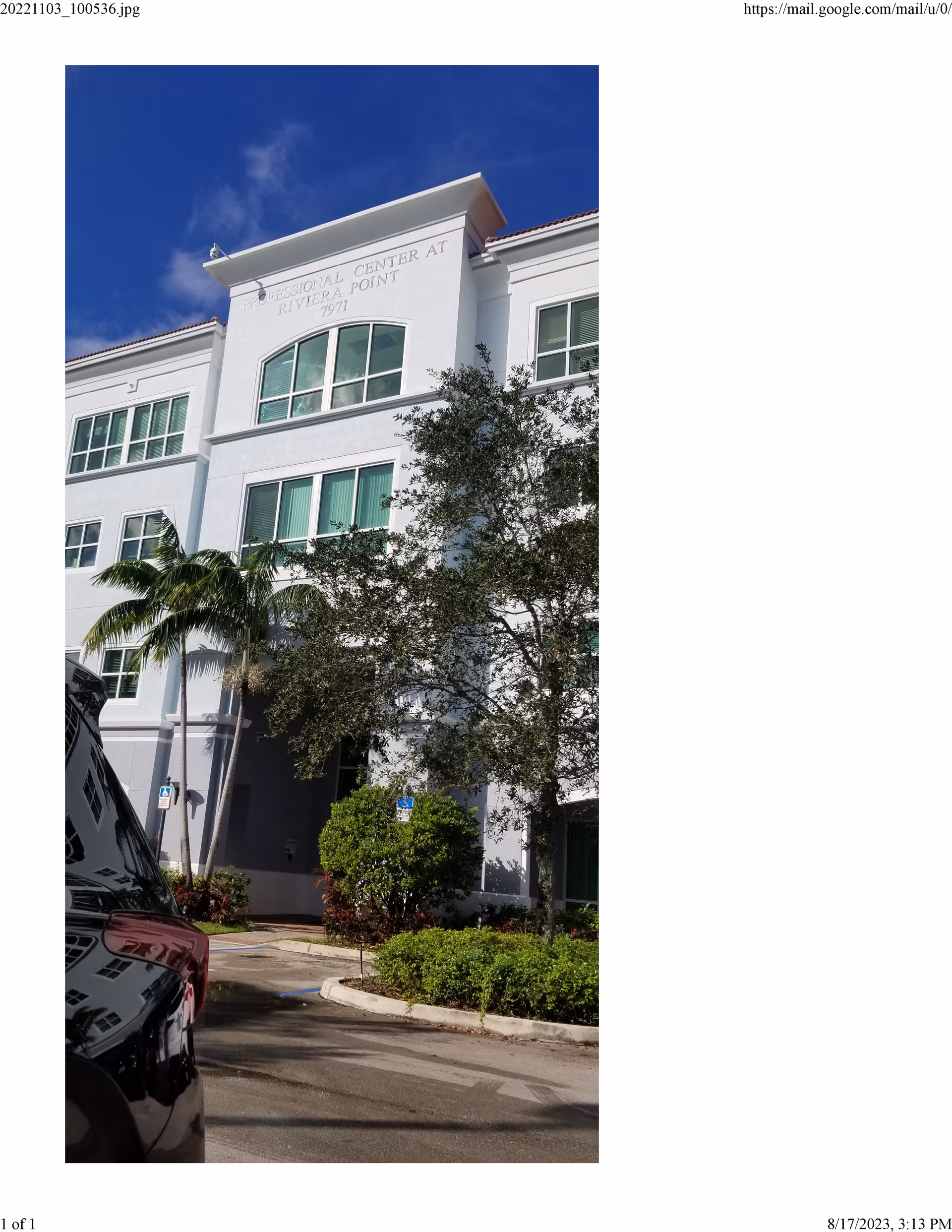 Exterior view of a white multi-story senior care building with palm trees.