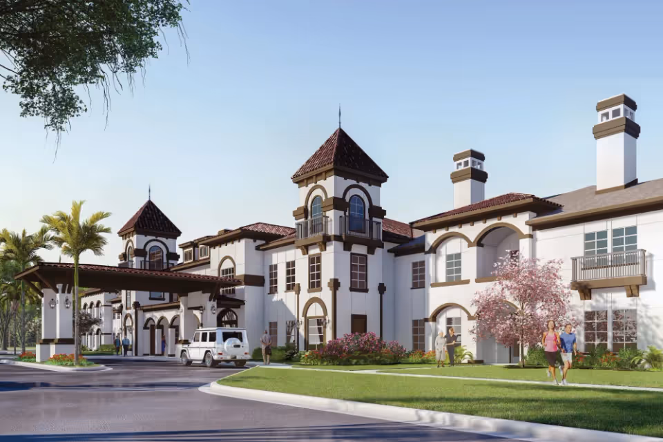 Mediterranean-style senior living building with towers, a covered porte-cochère, landscaped lawn, and people walking in front.