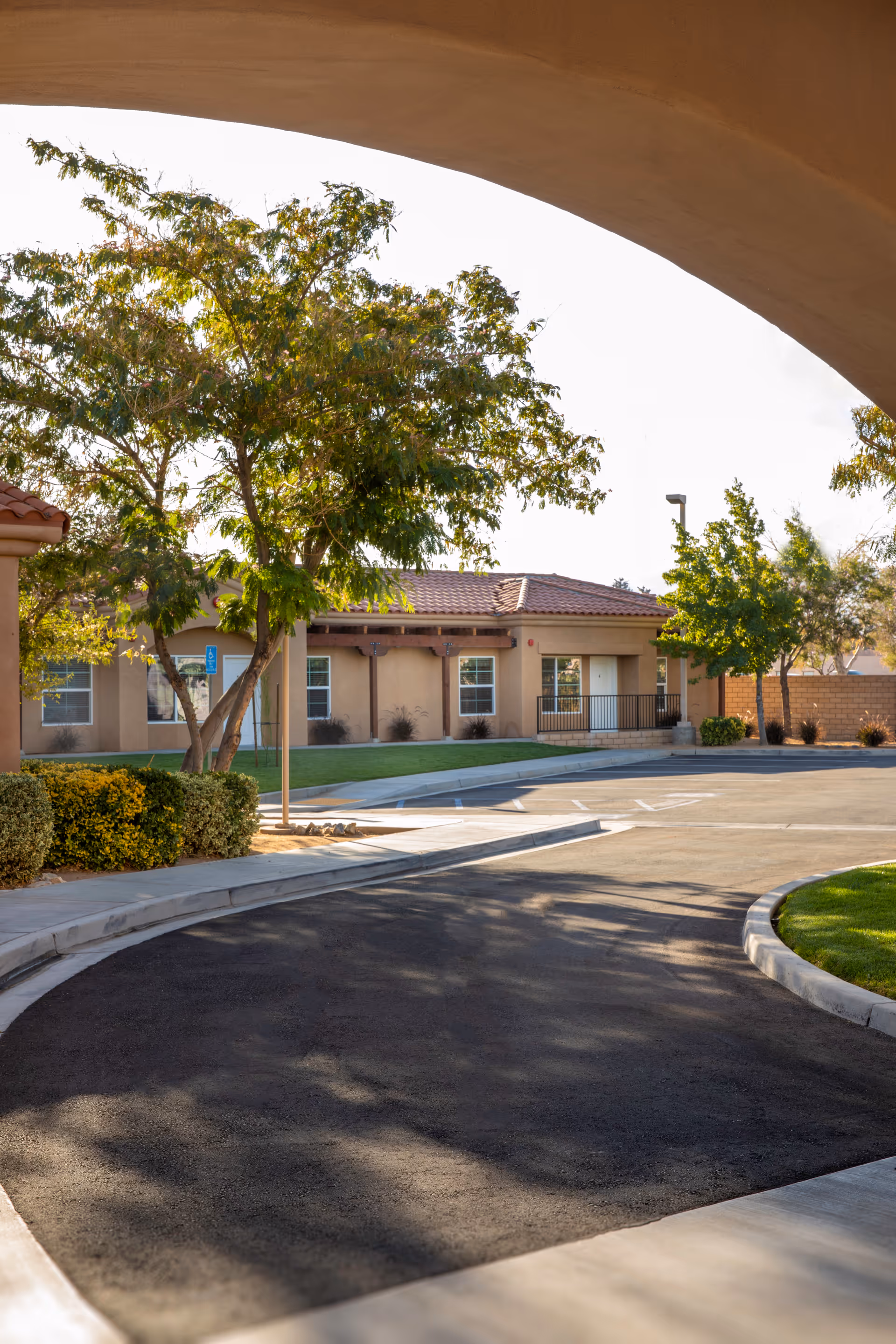 Exterior view of Casa Colina at Apple Valley with trees and parking.