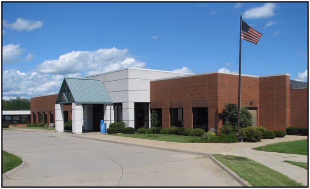 Exterior view of Van Buren County Hospital brick building with flag, entrance, and manicured grounds.