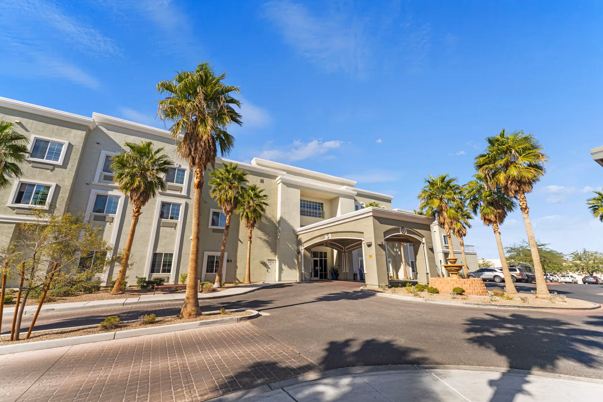 Exterior view of Volante of Las Vegas with palm trees and a covered entrance.