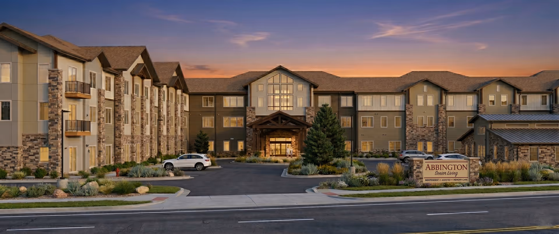 Exterior view of Abbington Senior Living of Littleton at sunset with sign.
