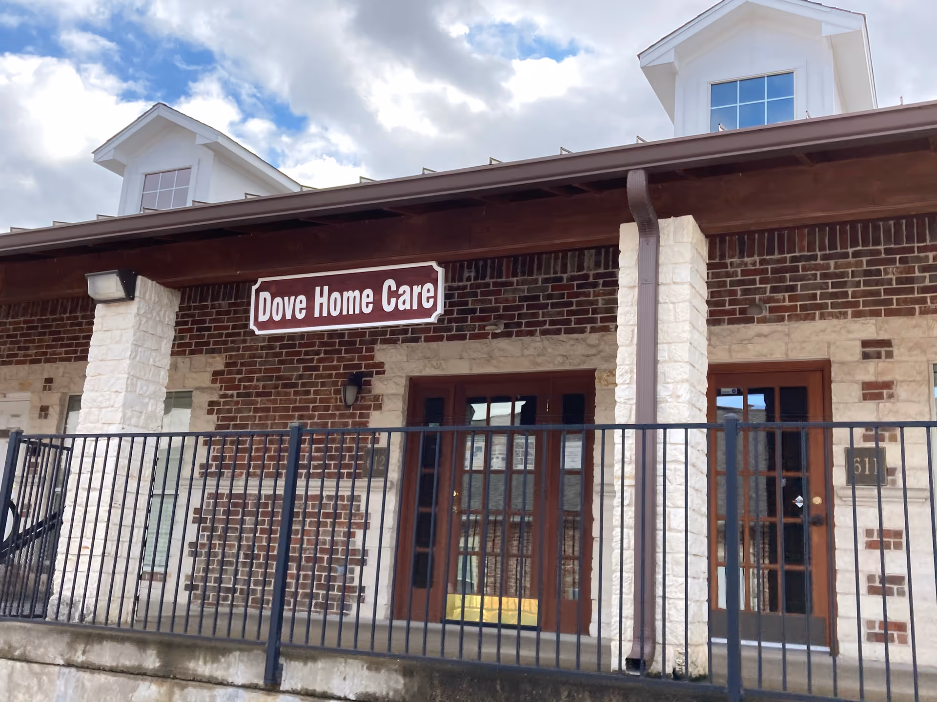 Front exterior of Dove Home Care facility with brick walls and double doors