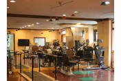 Interior of a senior living center gym with exercise machines and chairs.