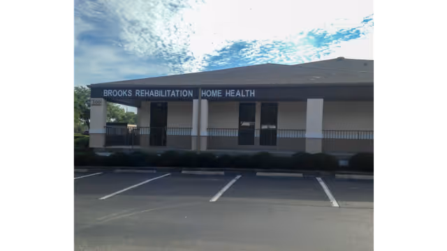 Single-story medical building with a covered entrance and Brooks Rehabilitation Home Health sign.