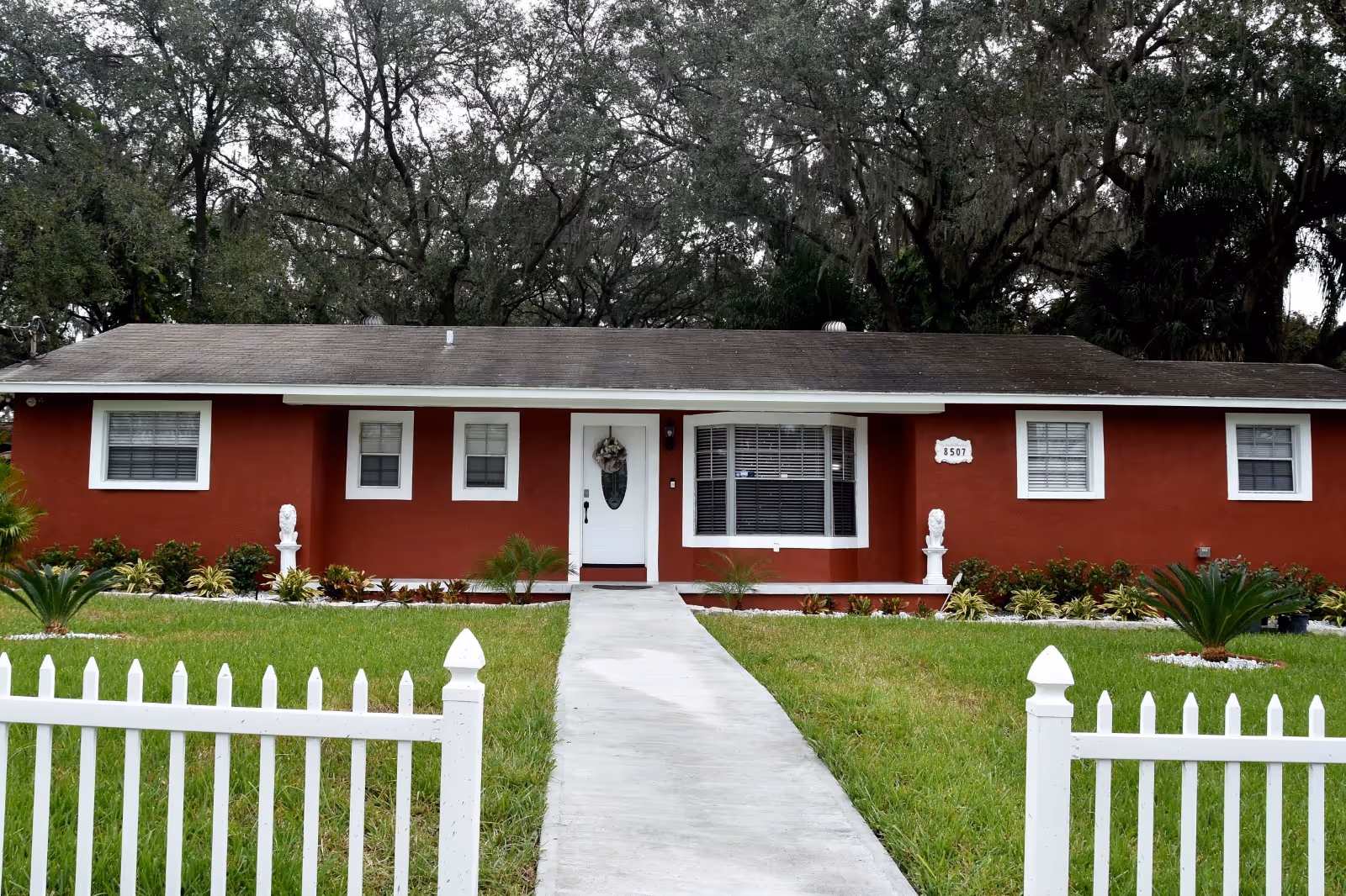 Red single-story facility with white trim, front walkway, and a white picket fence.