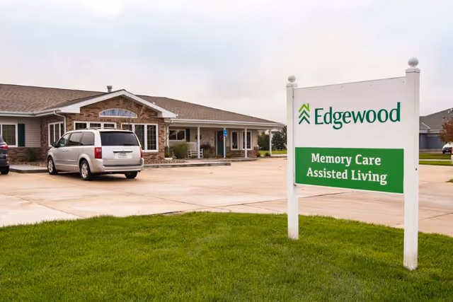 Exterior view of Edgewood Fremont Senior Living with a front sign and parking area