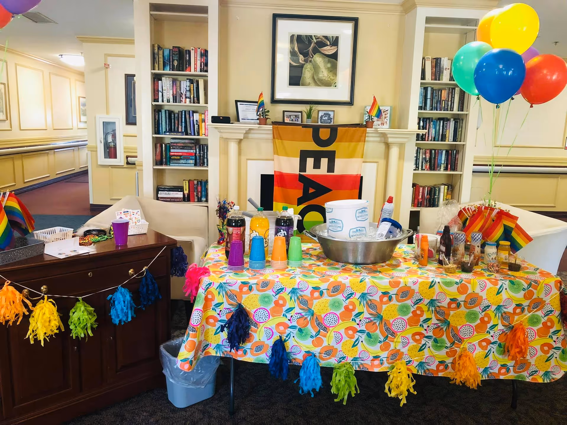 Decorated Prescott House living room with a colorful party table, balloons, and rainbow decorations.
