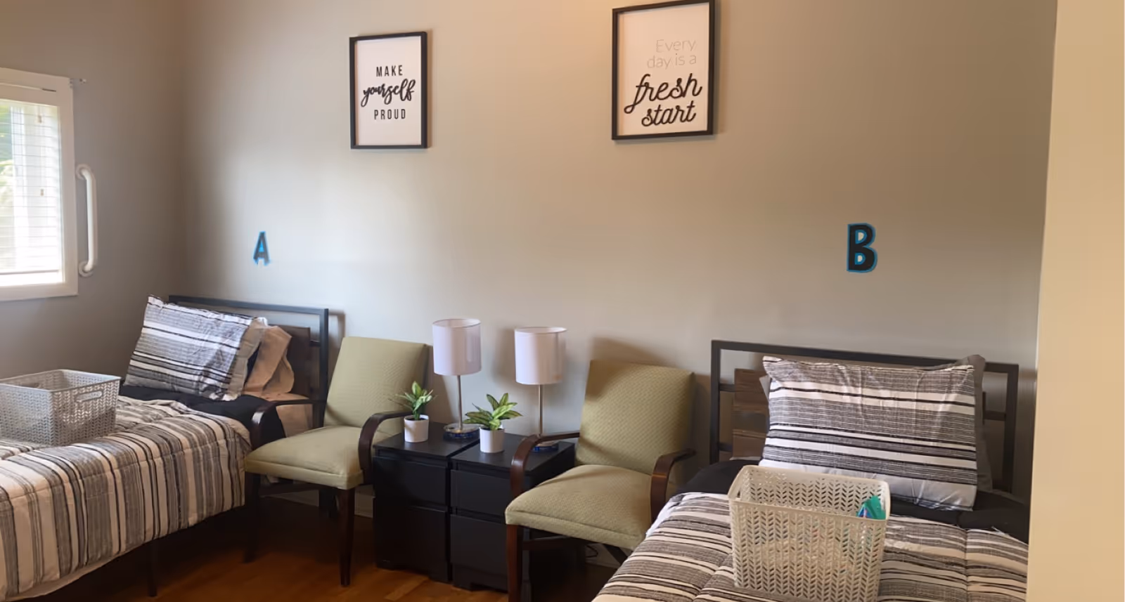 Shared bedroom in a senior living facility with two beds, chairs, and decorative wall art.