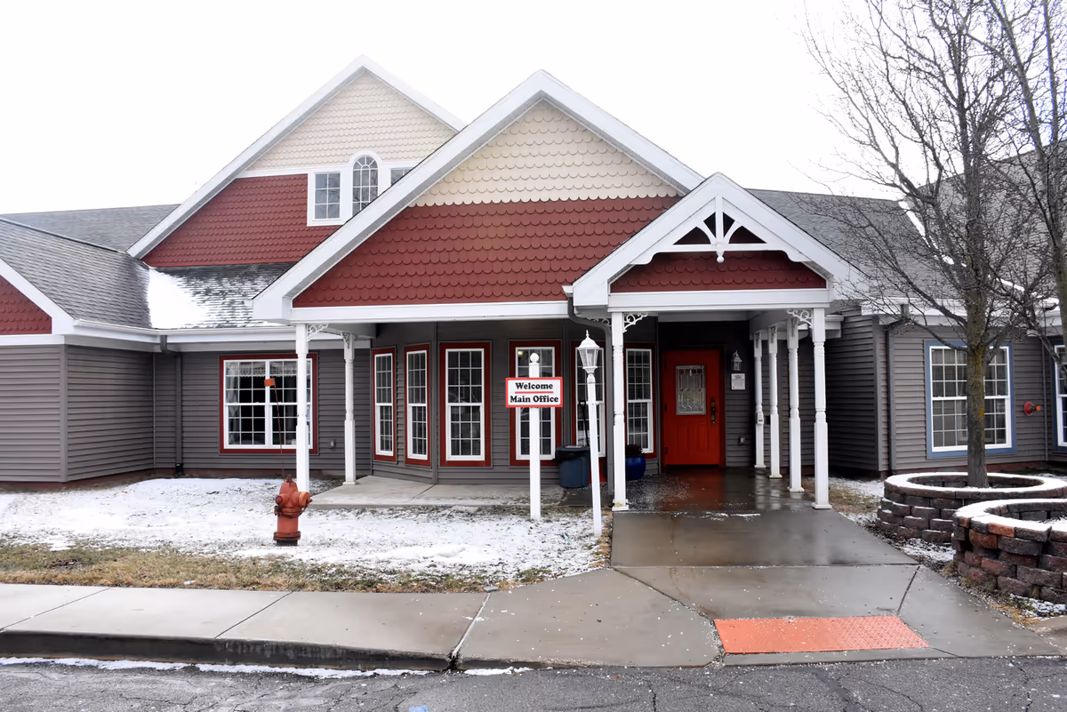 Exterior view of Caretel Inns of St. Joseph building with red accents and a covered entrance.