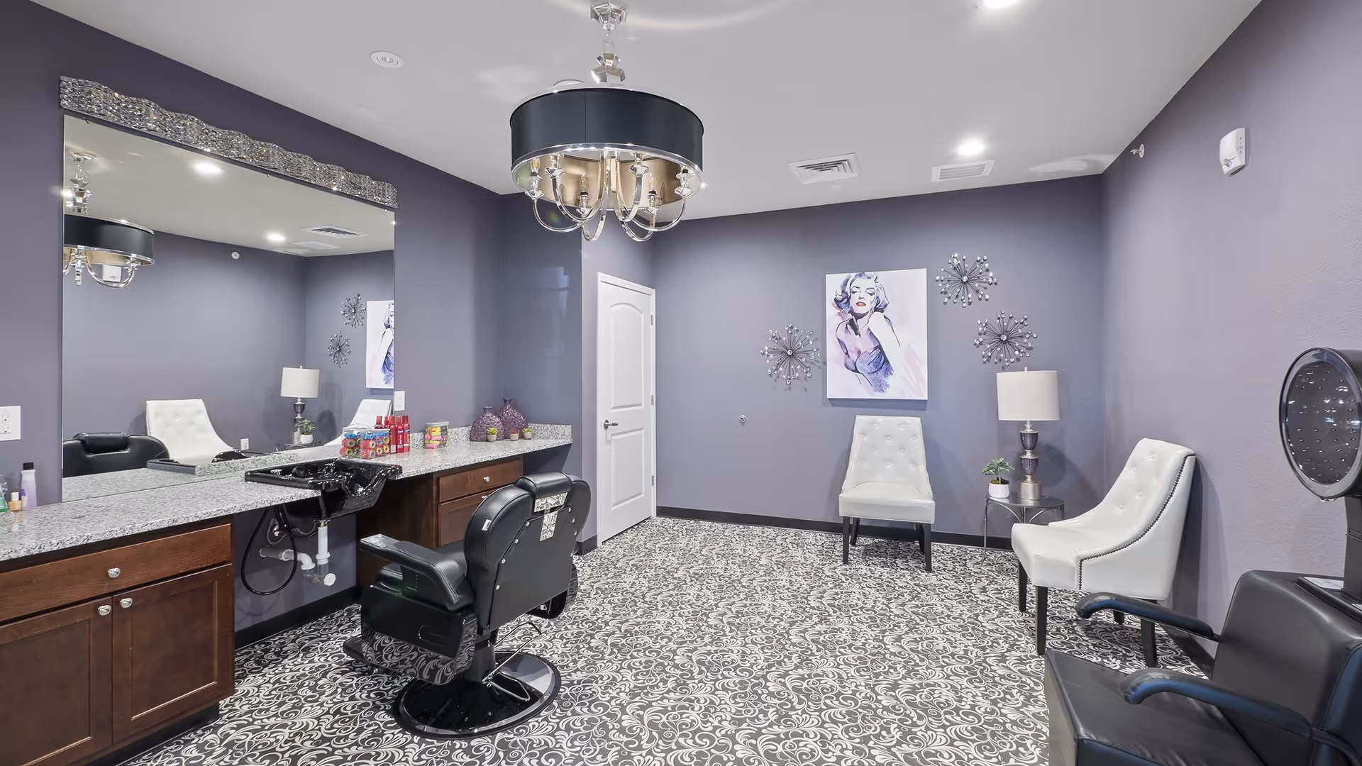 Hair salon in a purple room with large mirror, styling chair, and granite counter.