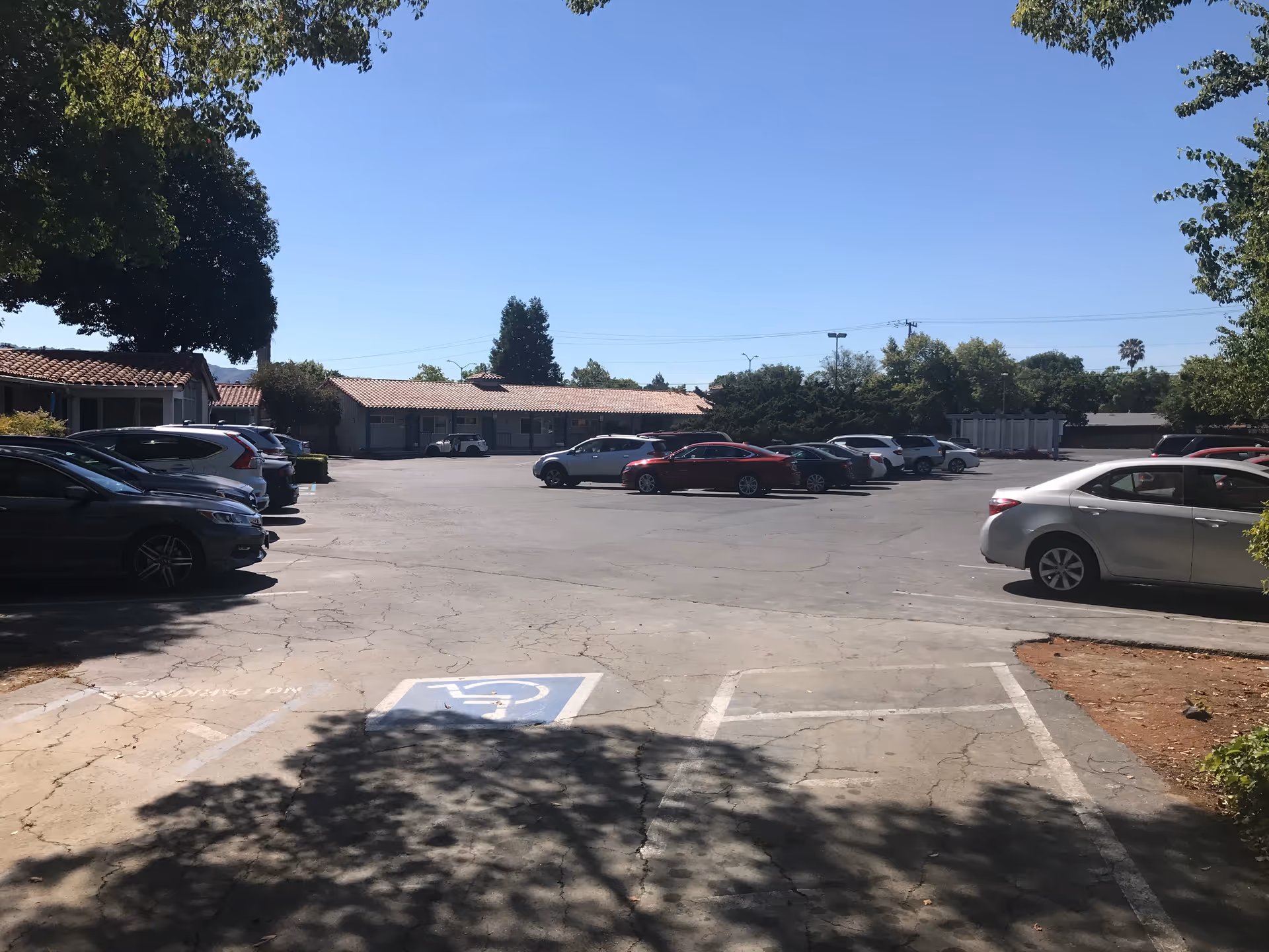 Parking lot in front of a single-story building with a handicap space visible.