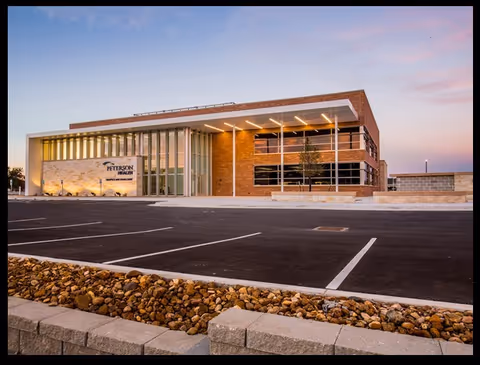 Peterson Home Care building with glass entrance and empty parking lot at dusk
