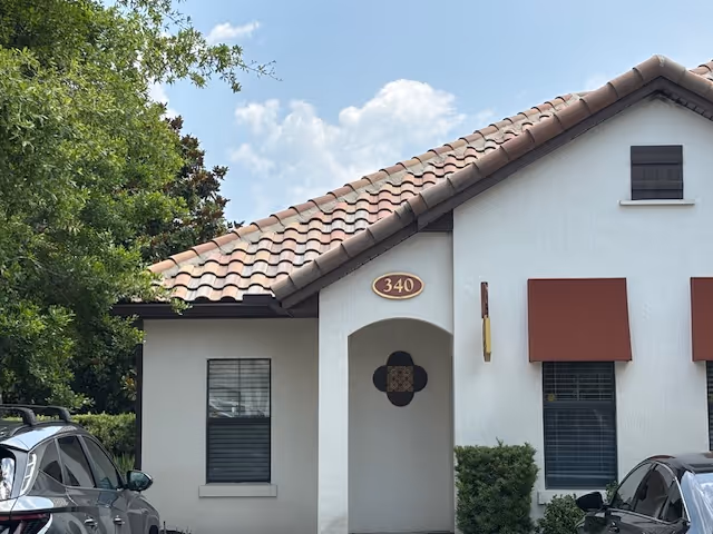 Front view of a white stucco senior living facility with a red-tiled roof.