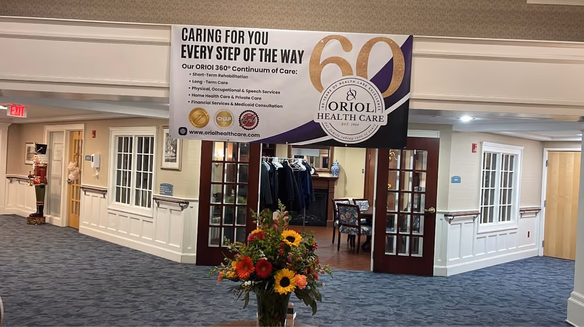 Lobby area of Oriol Health Care featuring a large entrance banner and flower bouquet.