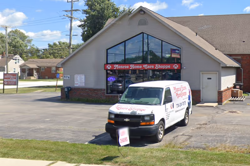 Monroe Home Care Shoppe storefront with a glass front and a white van parked outside.