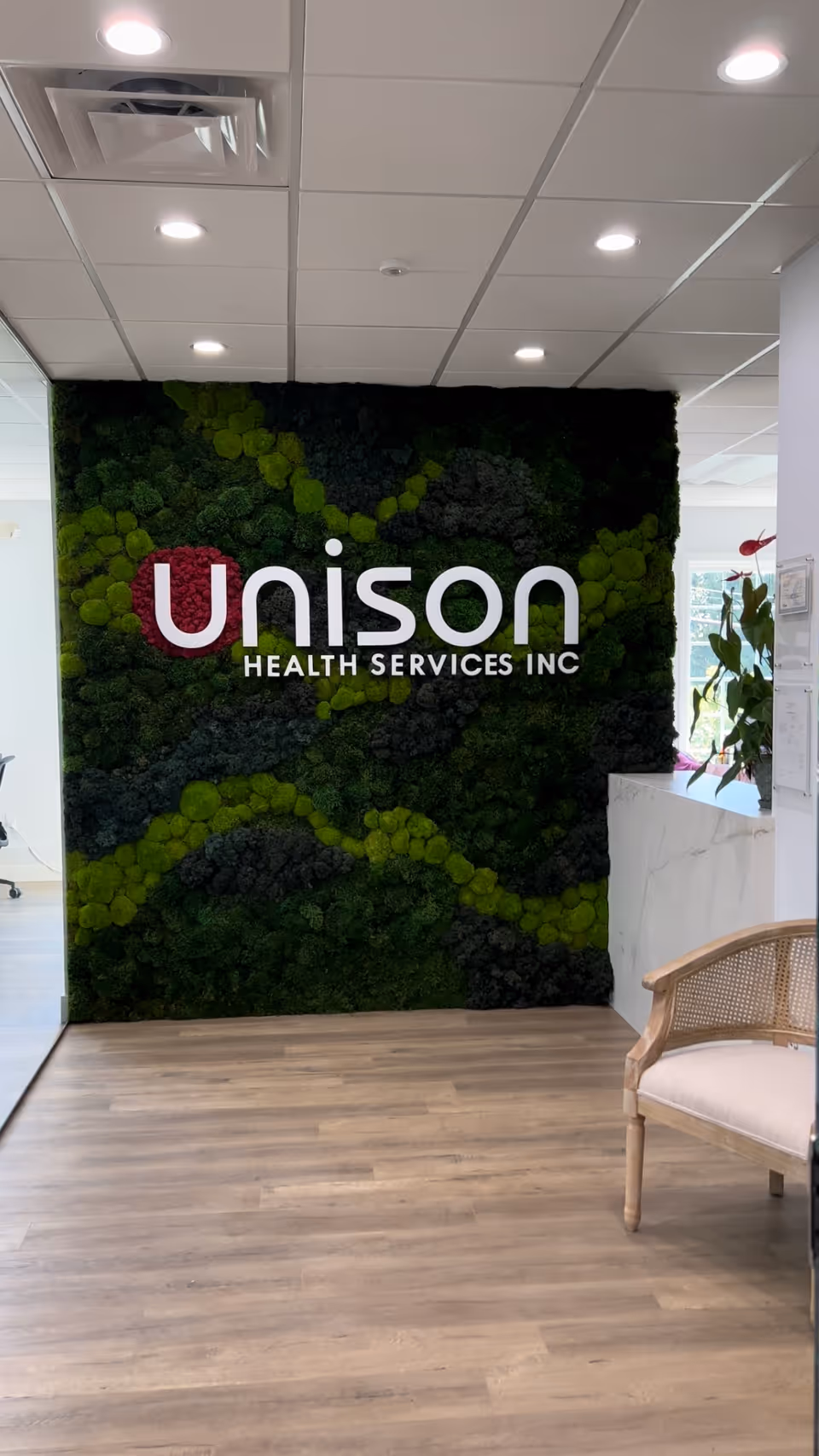 Interior lobby with a moss wall and Unison Health Services Inc sign.