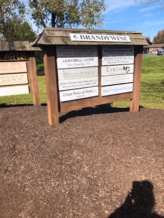 Outdoor wooden directory sign listing 4 Your Peace of Mind Home Health Agency among nearby businesses.