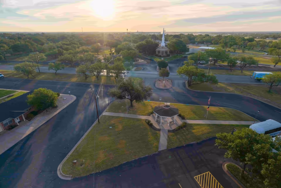 Aerial view of Baptist Retirement Community campus with trees, roads, and a central gazebo.