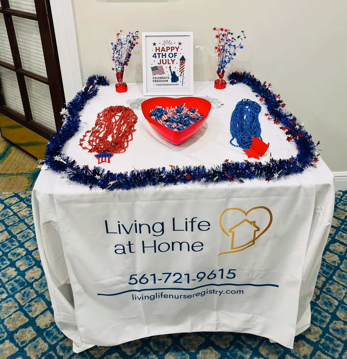 Patriotic Fourth of July table display with candy bowl and branded Living Life at Home cloth.