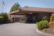 Front view of Bridgeview Care facility entrance with a covered driveway and American flag.