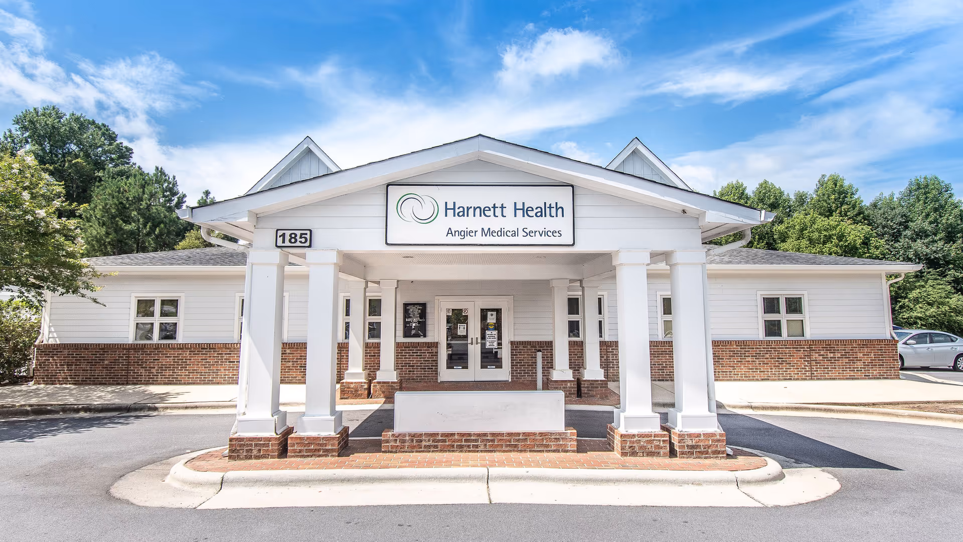White building with brick base, columns, and a covered entrance labeled Angier Medical Services.