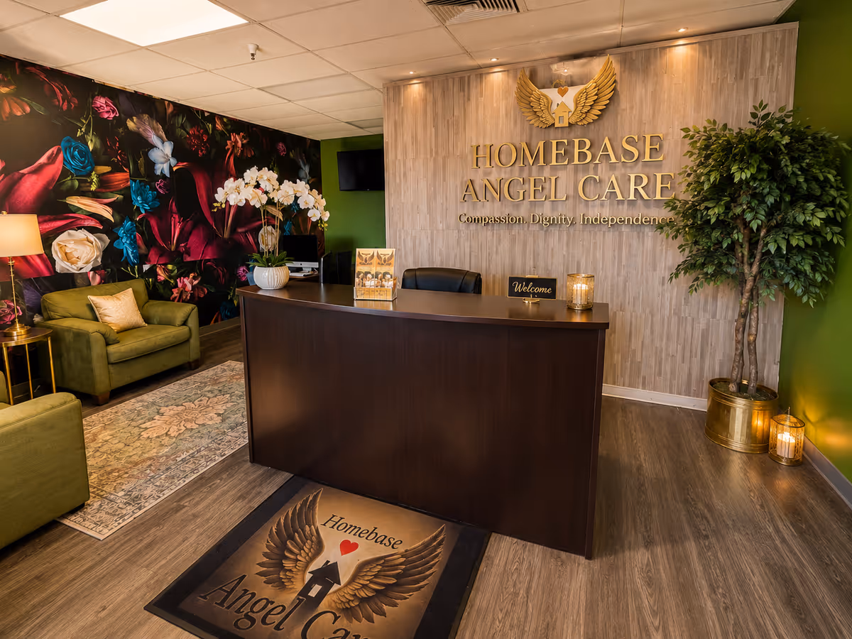 Reception lobby with dark wood desk, logo wall, floral mural, and green seating area.