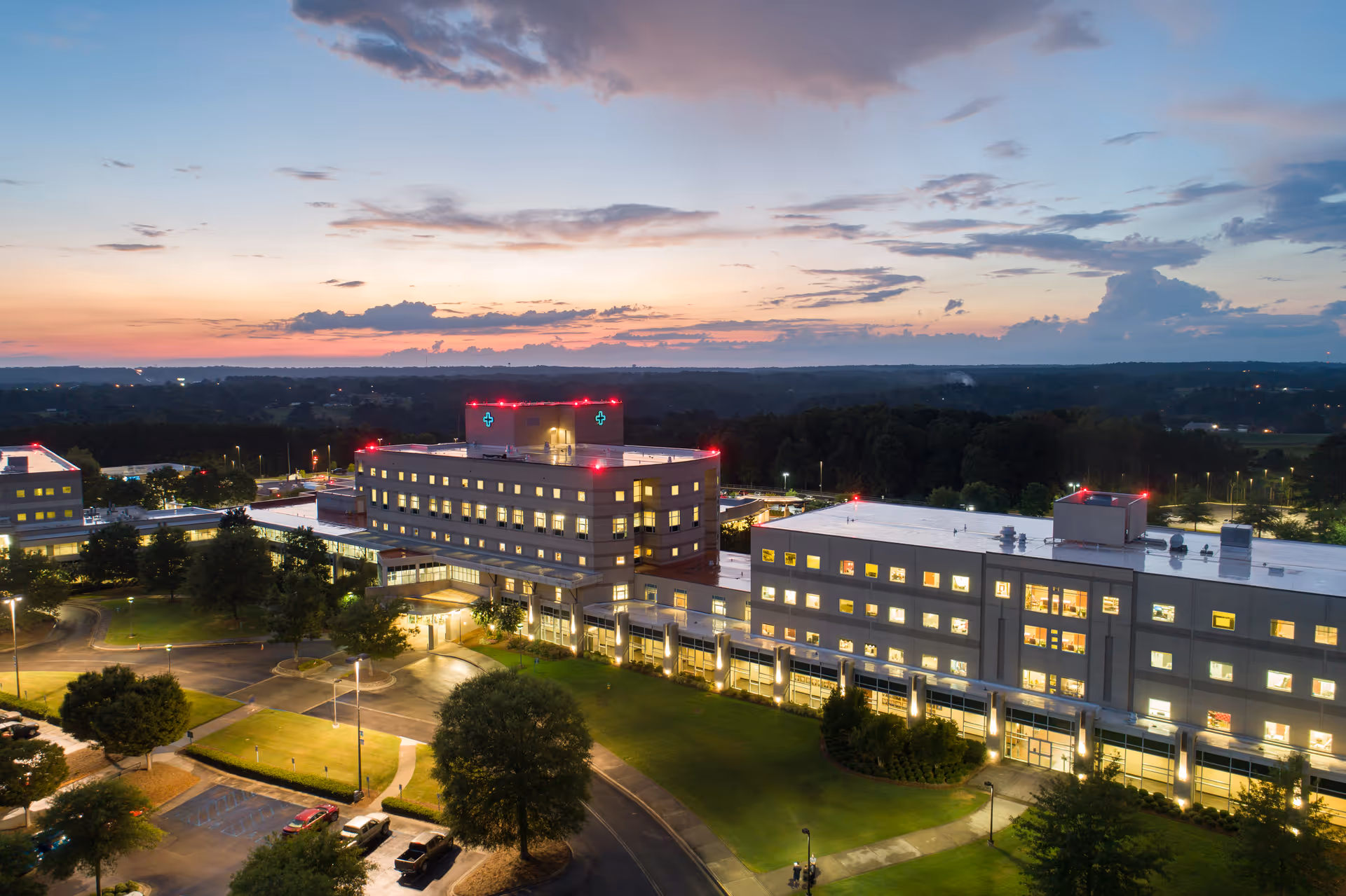 Sunset over Cullman Regional Medical Center campus with illuminated windows and parking lots.